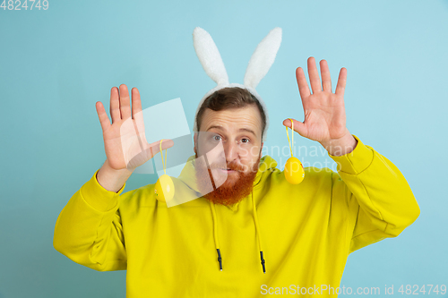 Image of Easter bunny man with bright emotions on blue studio background