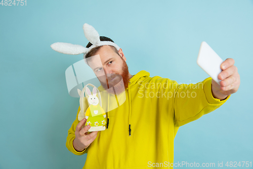 Image of Easter bunny man with bright emotions on blue studio background