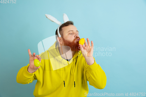 Image of Easter bunny man with bright emotions on blue studio background