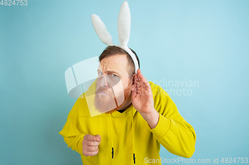 Image of Easter bunny man with bright emotions on blue studio background