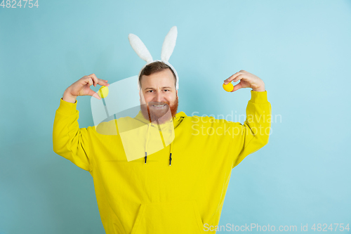 Image of Easter bunny man with bright emotions on blue studio background