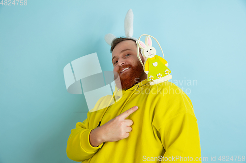 Image of Easter bunny man with bright emotions on blue studio background