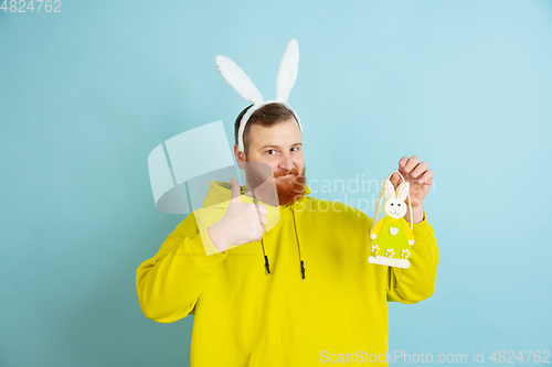 Image of Easter bunny man with bright emotions on blue studio background