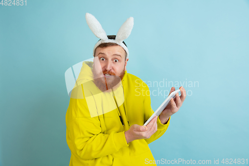 Image of Easter bunny man with bright emotions on blue studio background