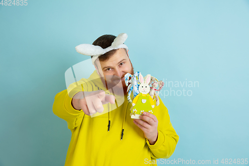 Image of Easter bunny man with bright emotions on blue studio background