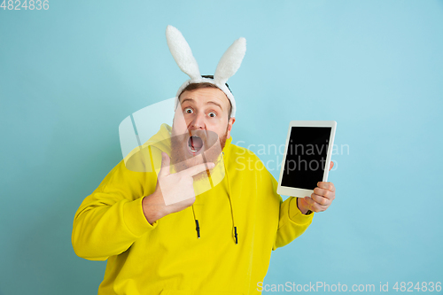 Image of Easter bunny man with bright emotions on blue studio background