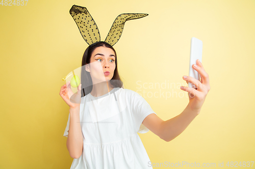 Image of Easter bunny woman with bright emotions on yellow studio background