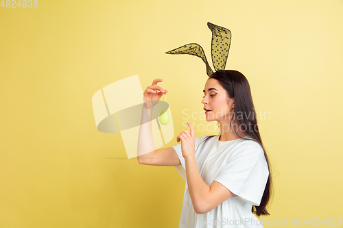 Image of Easter bunny woman with bright emotions on yellow studio background