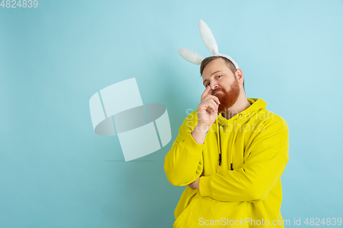 Image of Easter bunny man with bright emotions on blue studio background