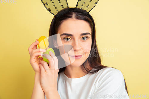 Image of Easter bunny woman with bright emotions on yellow studio background