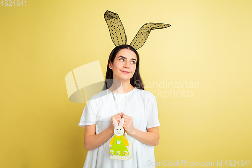 Image of Easter bunny woman with bright emotions on yellow studio background