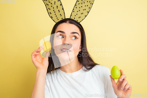 Image of Easter bunny woman with bright emotions on yellow studio background