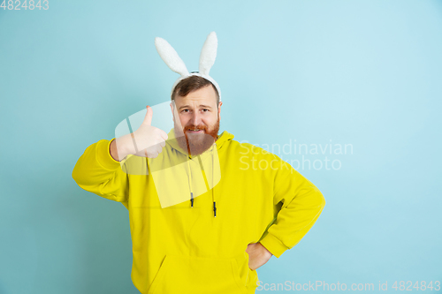 Image of Easter bunny man with bright emotions on blue studio background