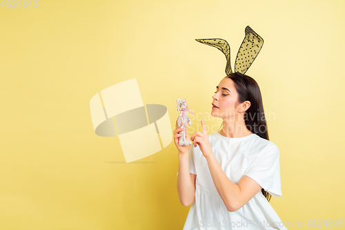 Image of Easter bunny woman with bright emotions on yellow studio background