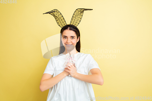 Image of Easter bunny woman with bright emotions on yellow studio background