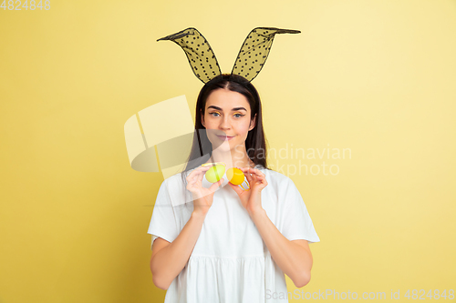 Image of Easter bunny woman with bright emotions on yellow studio background