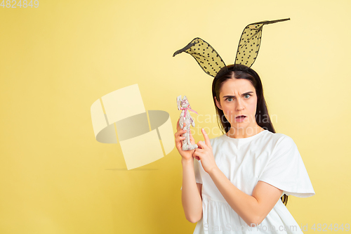 Image of Easter bunny woman with bright emotions on yellow studio background