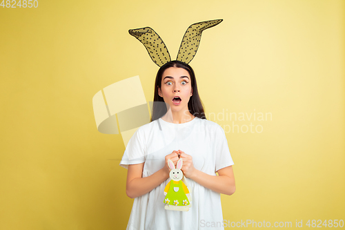 Image of Easter bunny woman with bright emotions on yellow studio background