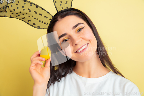 Image of Easter bunny woman with bright emotions on yellow studio background