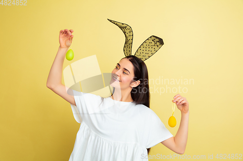 Image of Easter bunny woman with bright emotions on yellow studio background