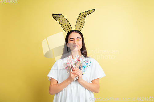 Image of Easter bunny woman with bright emotions on yellow studio background