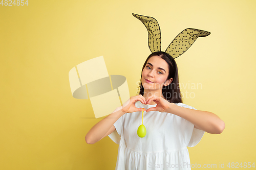 Image of Easter bunny woman with bright emotions on yellow studio background