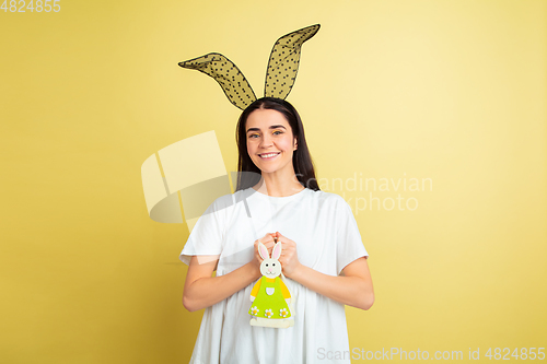 Image of Easter bunny woman with bright emotions on yellow studio background