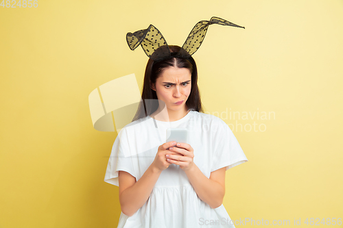 Image of Easter bunny woman with bright emotions on yellow studio background