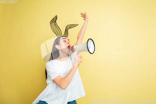 Image of Easter bunny woman with bright emotions on yellow studio background