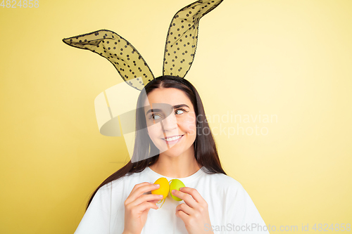 Image of Easter bunny woman with bright emotions on yellow studio background