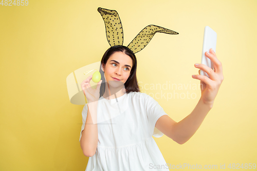 Image of Easter bunny woman with bright emotions on yellow studio background