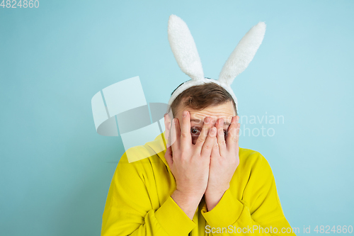 Image of Easter bunny man with bright emotions on blue studio background