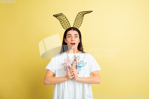 Image of Easter bunny woman with bright emotions on yellow studio background