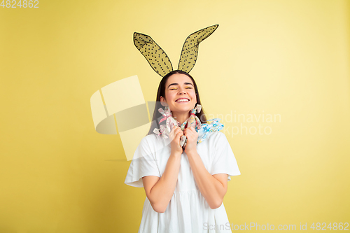 Image of Easter bunny woman with bright emotions on yellow studio background