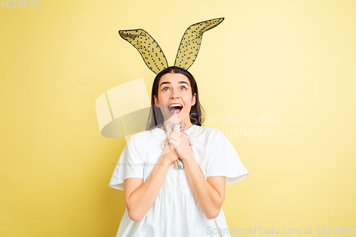 Image of Easter bunny woman with bright emotions on yellow studio background