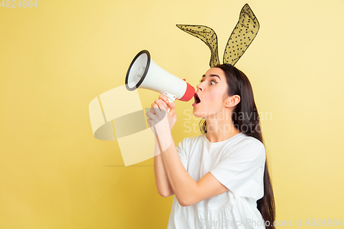 Image of Easter bunny woman with bright emotions on yellow studio background