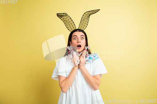 Image of Easter bunny woman with bright emotions on yellow studio background