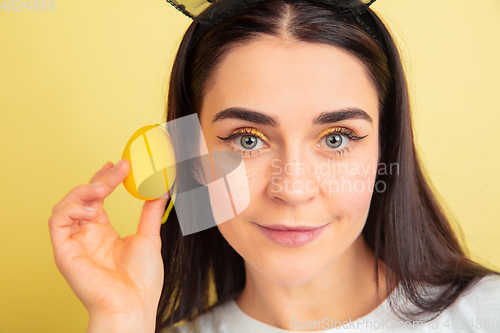 Image of Easter bunny woman with bright emotions on yellow studio background