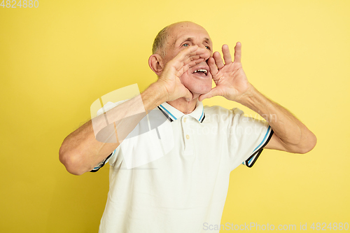 Image of Caucasian senior man\'s portrait isolated on yellow studio background