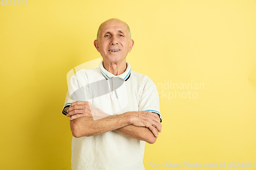 Image of Caucasian senior man\'s portrait isolated on yellow studio background