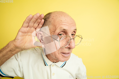Image of Caucasian senior man\'s portrait isolated on yellow studio background