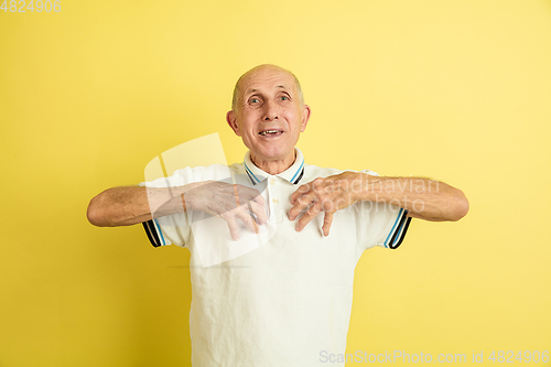 Image of Caucasian senior man\'s portrait isolated on yellow studio background