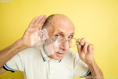 Image of Caucasian senior man\'s portrait isolated on yellow studio background