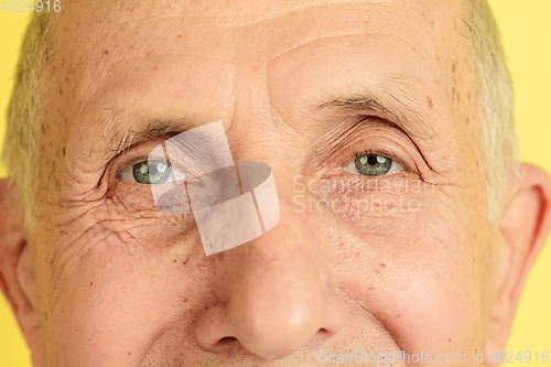 Image of Caucasian senior man\'s portrait isolated on yellow studio background
