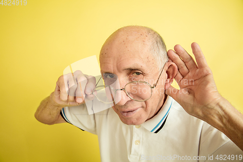 Image of Caucasian senior man\'s portrait isolated on yellow studio background