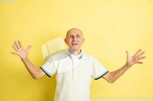 Image of Caucasian senior man\'s portrait isolated on yellow studio background