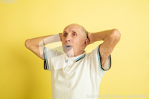 Image of Caucasian senior man\'s portrait isolated on yellow studio background