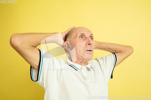 Image of Caucasian senior man\'s portrait isolated on yellow studio background