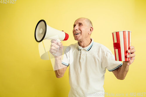 Image of Caucasian senior man\'s portrait isolated on yellow studio background