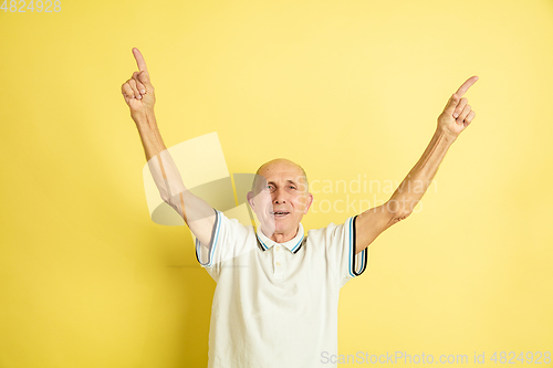 Image of Caucasian senior man\'s portrait isolated on yellow studio background